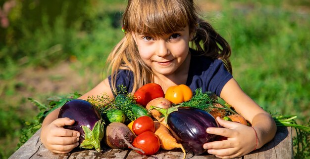 Foto niño con verduras en el jardín enfoque selectivo