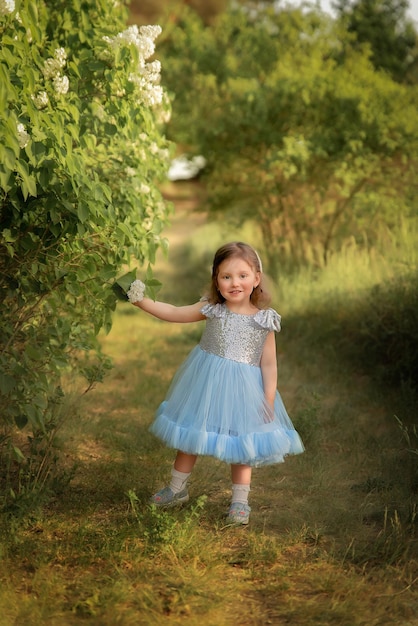 Un niño con un vestido azul juega en el parque, juega en el bosque, una niña con una canasta recoge flores.