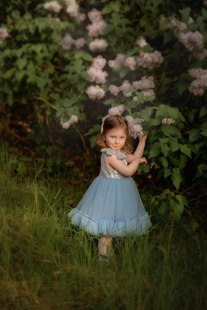 Un niño con un vestido azul juega en el parque, juega en el bosque, una niña con una canasta recoge flores.