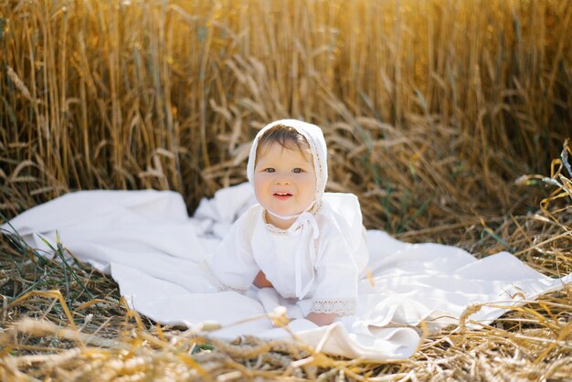 Un niño vestido de blanco se relaja al aire libre en un campo