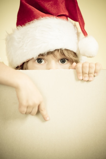 Niño vestido de Santa Claus con concepto de vacaciones de Navidad de papel en blanco