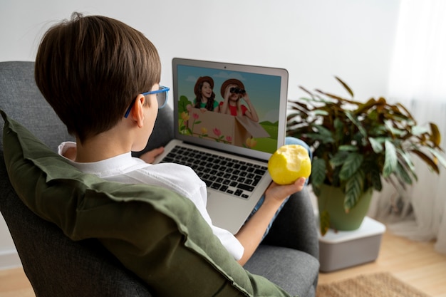 Foto niño viendo películas en la computadora portátil