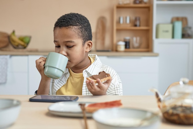 Niño viendo videos en la mesa de la cocina