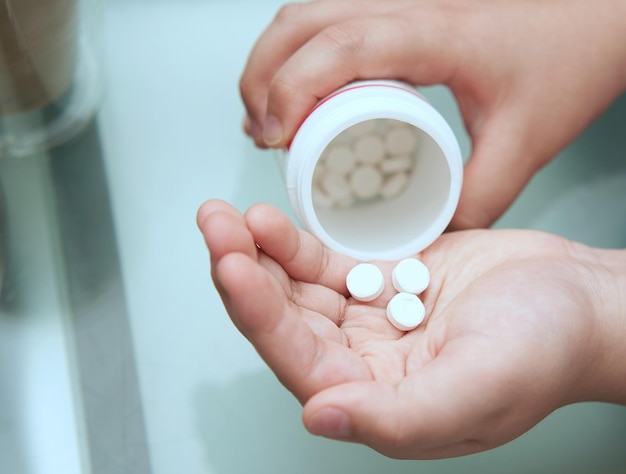 Niño vierte pastillas en la palma de la mano