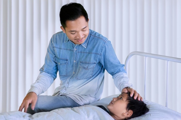 Niño visitado por su padre en el hospital