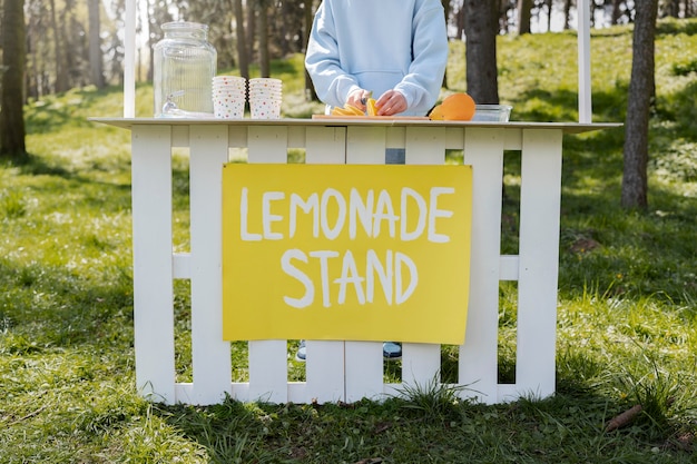 Foto niño de vista frontal haciendo limonada