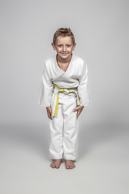 Niño vistiendo judogi de artes marciales en la posición rei
