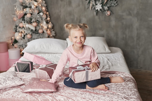 Niño vistiendo pijamas y abriendo regalo de Navidad