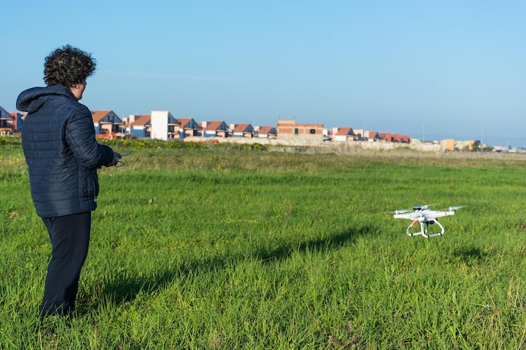 Foto niño volando en un drone en un campo cubierto de hierba