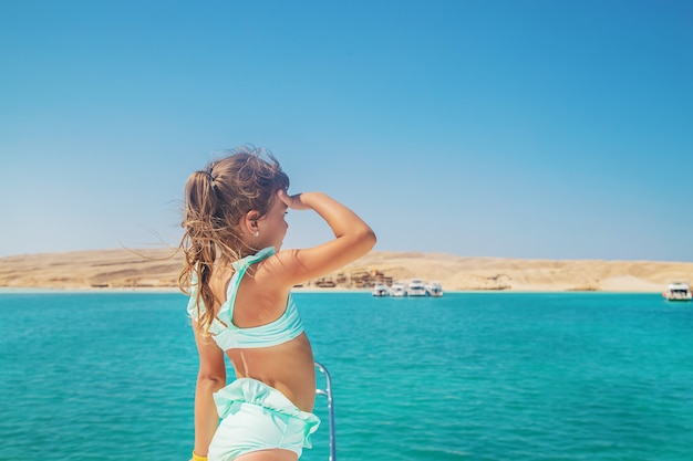 Un niño en un yate navegando por el mar.