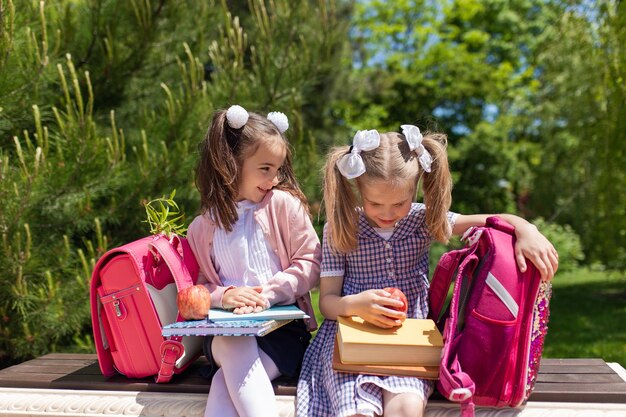 Niño yendo a la escuela Dos niñas con libros y manzanas en el primer día de clases