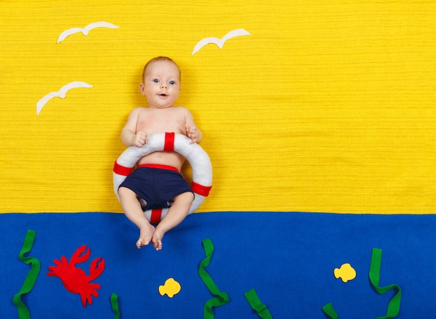 El niño se zambulle en una piscina imaginaria. Soñando con mar, vacaciones