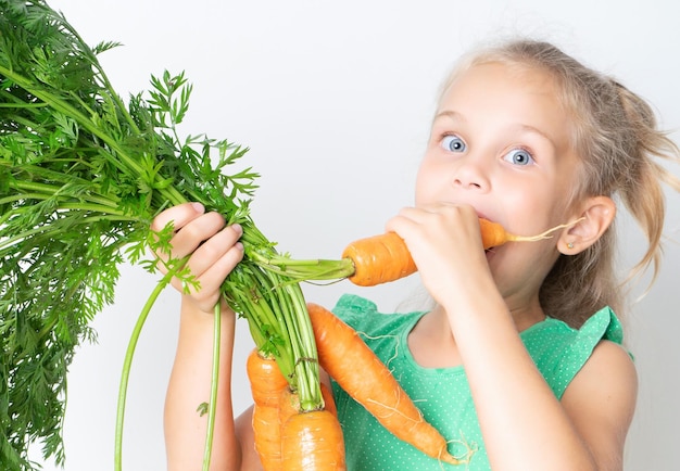 Un niño con zanahorias vegetales.