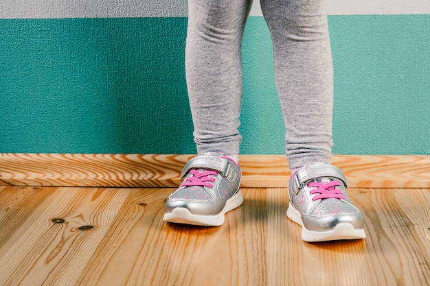 Niño en zapatillas sobre superficie de madera