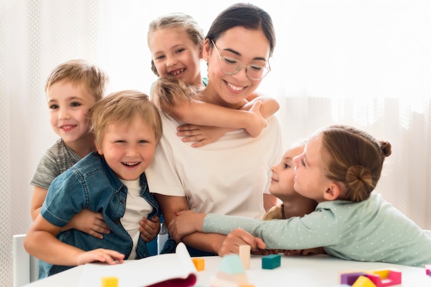 Foto niños abrazando a su maestra