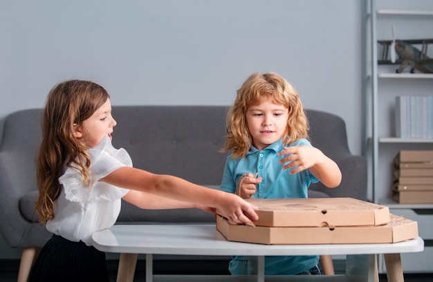 Los niños abren la caja de la pizza en casa los niños se preparan para comer pizza vegetariana comida rápida italiana lindo poco