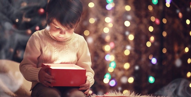 Niños abriendo regalos de Navidad Niños bajo el árbol de Navidad con cajas de regalo