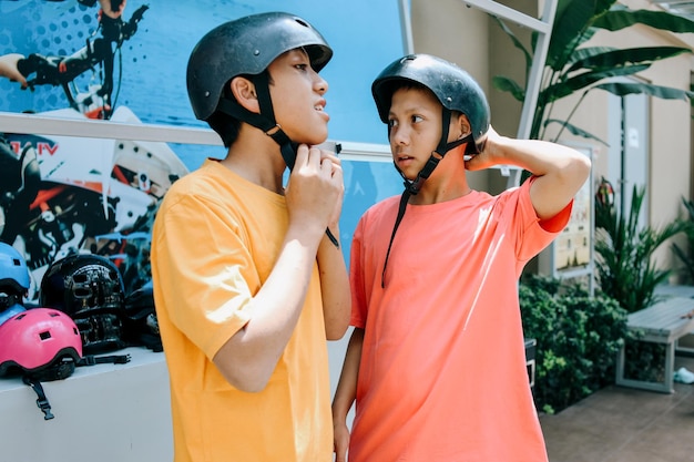 Los niños se abrochan un casco protector listo para montar.