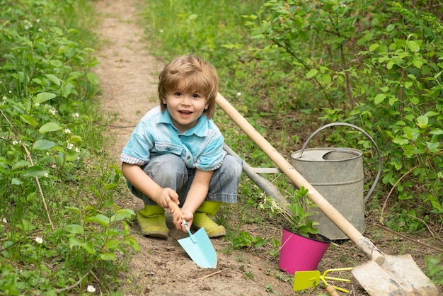 Niños actividades de verano infancia despreocupada niño agricultor examinando cultivo de higo común en plantat ...