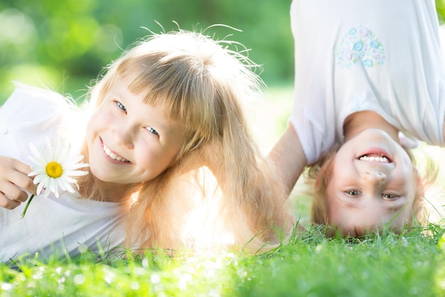Niños activos felices jugando en la hierba verde en el parque de primavera