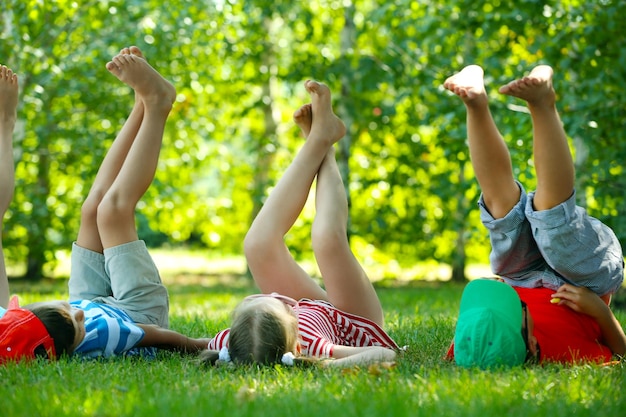 Foto niños activos felices tirados en la hierba verde en el parque