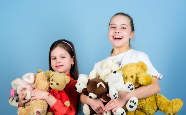 Niños adorables chicas lindas juegan juguetes de peluche Infancia feliz Cuidado de niños Hermanas mejores amigas juegan Dulce infancia Concepto de infancia Suavidad y ternura Suavizante de ropa Amor y amistad