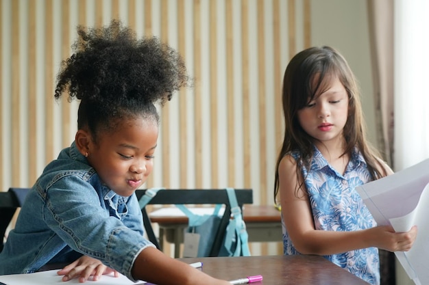 Niños africanos dibujando y haciendo la tarea en el aula niña feliz estudio divertido en la escuela