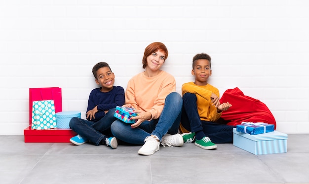 Niños afroamericanos con su madre entre muchos regalos para las fiestas navideñas