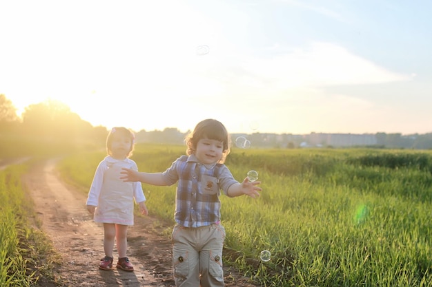 Niños al aire libre en la naturaleza en el campo de hierba.