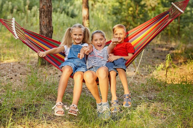 Niños al aire libre sentados en una hamaca colorida