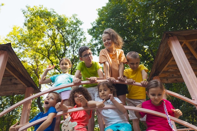 Los niños alegres descansan en una casa de árbol de madera.