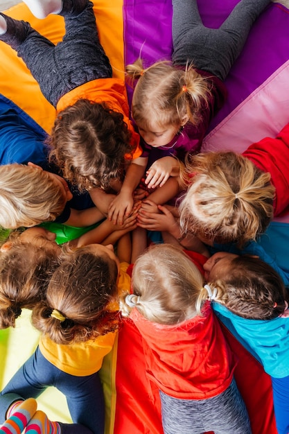 Foto niños alegres jugando juegos de formación de equipos en un piso