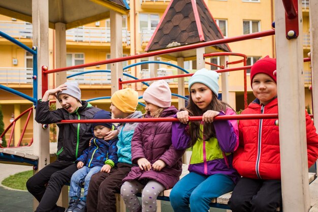 Niños alegres en el patio de recreo al aire libre a principios de primavera