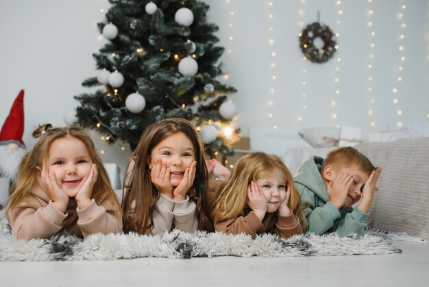 Niños alegres con regalos próximo árbol de Navidad