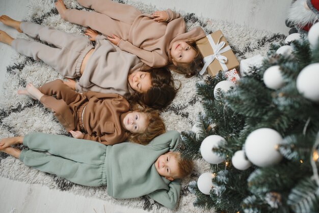 Niños alegres con regalos próximo árbol de Navidad