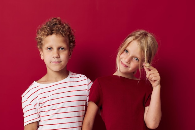 Niños alegres sonriendo y posando con ropa informal contra un fondo aislado sin alteraciones