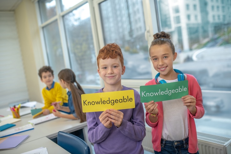 Foto niños alegres sosteniendo tabletas con palabras en inglés