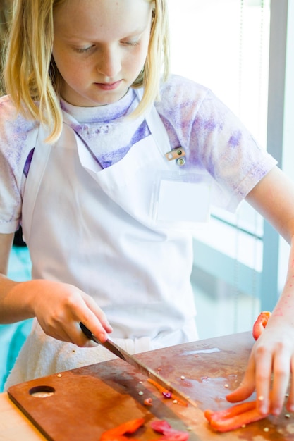 Niños aprendiendo a cocinar en una clase de cocina.