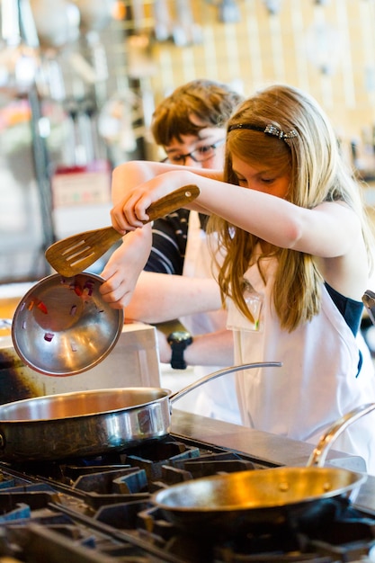 Niños aprendiendo a cocinar en una clase de cocina.