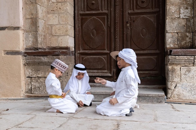 Niños de Arabia Saudita jugando fuera de la casa en el casco antiguo de Jeddah, Srabia Saudita