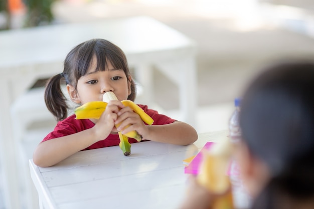 Los niños asiáticos en la cantina almorzando o desayunando se divierten