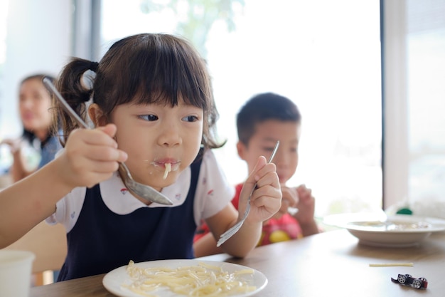 Los niños asiáticos disfrutan comiendo comida