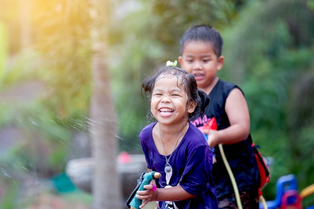 Niños asiáticos se divierten jugando con agua juntos en el festival de Songkran Tailandia