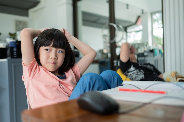 Los niños asiáticos están aprendiendo computadora en línea, escuela en casa