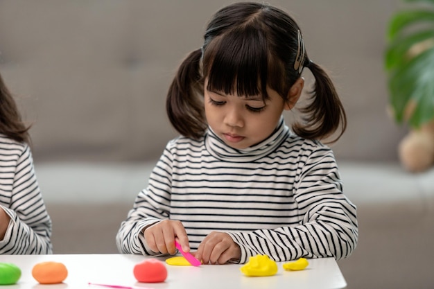 Los niños asiáticos juegan con moldes de arcilla aprendiendo a través del juego