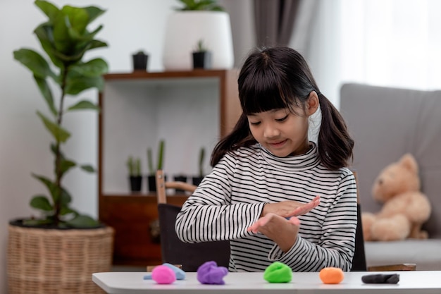 Los niños asiáticos juegan con moldes de arcilla aprendiendo a través del juego