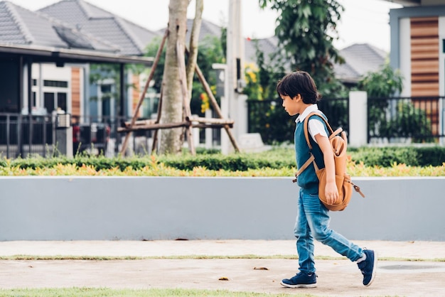 Niños asiáticos y mochila de estudiante caminando al aire libre yendo a la escuela