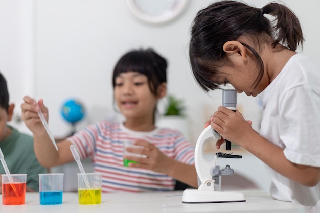 Niños asiáticos observan con entusiasmo experimentos de química