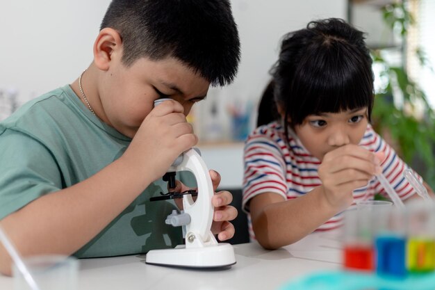 Niños asiáticos observan con entusiasmo experimentos de química