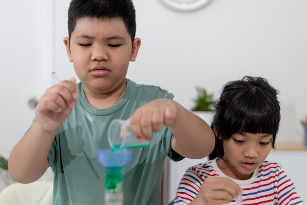 Niños asiáticos observan con entusiasmo experimentos de química